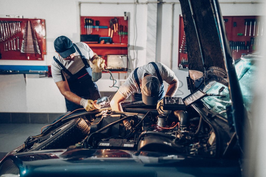 Two man working on repair of old timer. 1973 date of manifacture